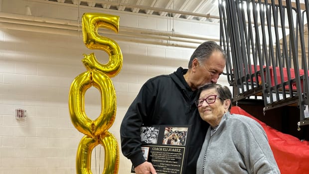 Davis boys basketball coach Eli Juarez gives his mother, Rosa, a kiss on top of the head during a postgame celebration Saturday night after the Pirates defeated West Valley in CBBN action at West Valley. 